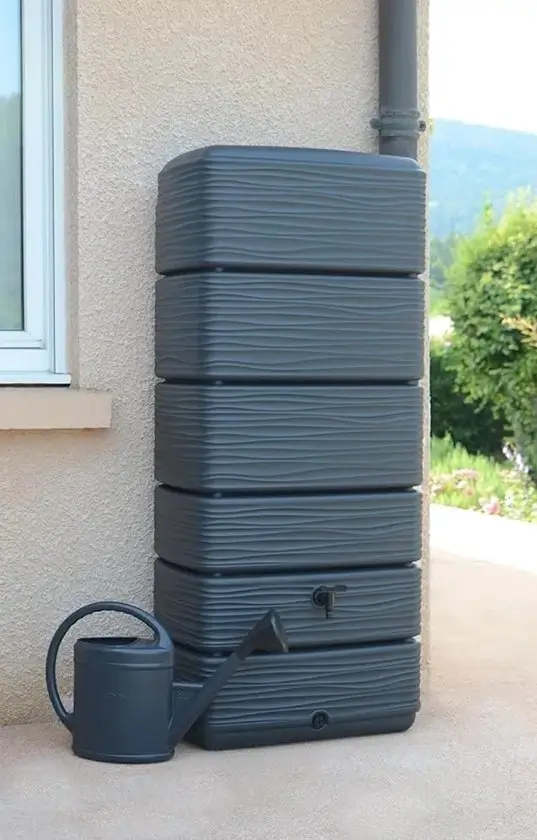 HomeSaver 320L Muurtank Zwart naast een moderne tuinmuur